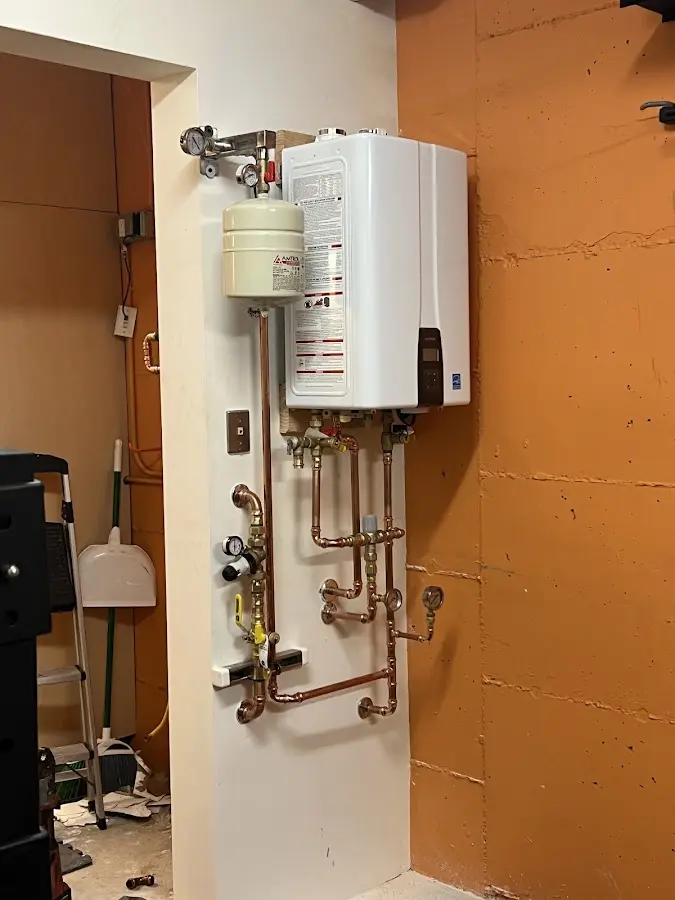 Plumbing technician inspecting water heater connections in Claremont